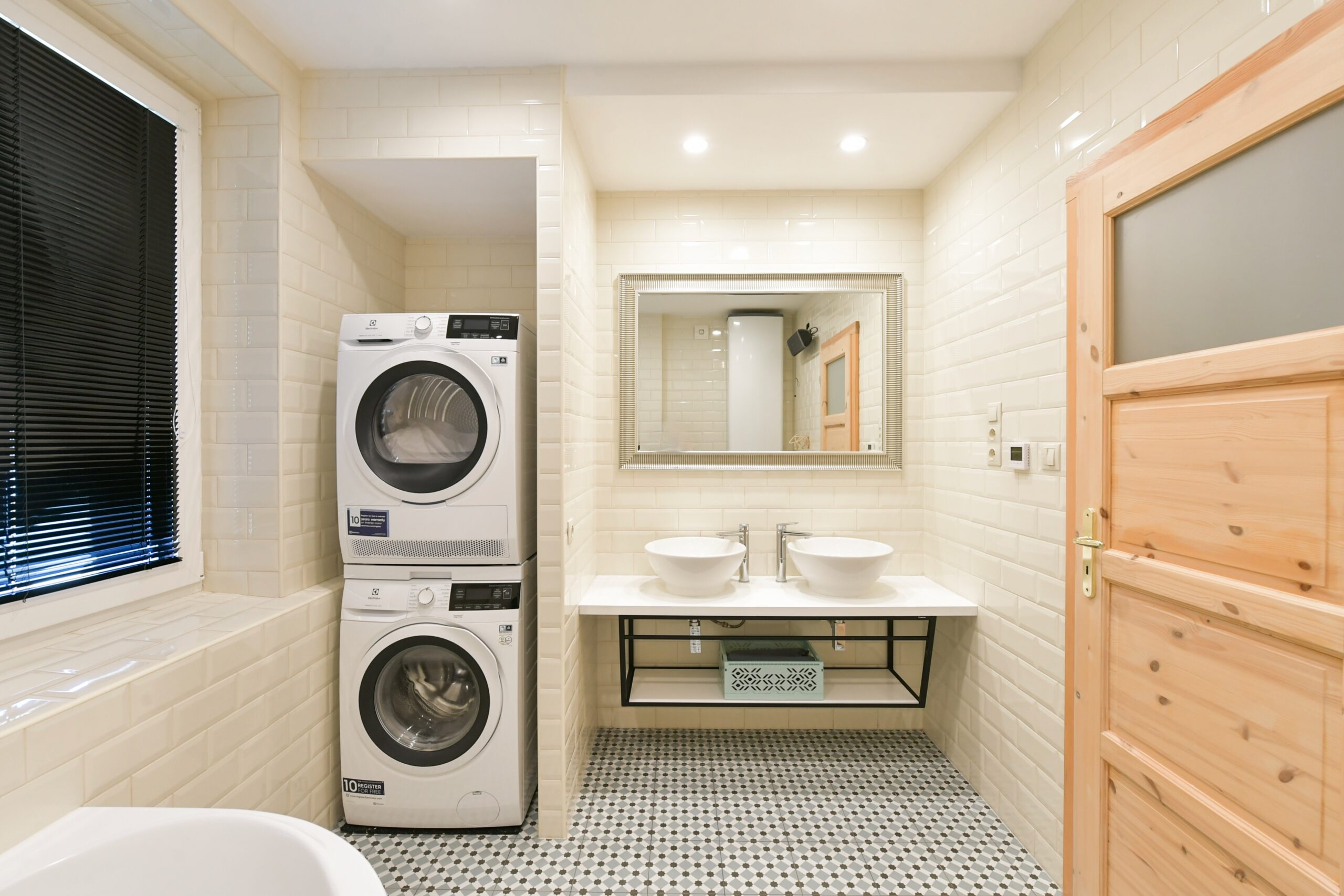 Snímek z vybavení apartmánu, koupelna s pračkou a sušičkou.